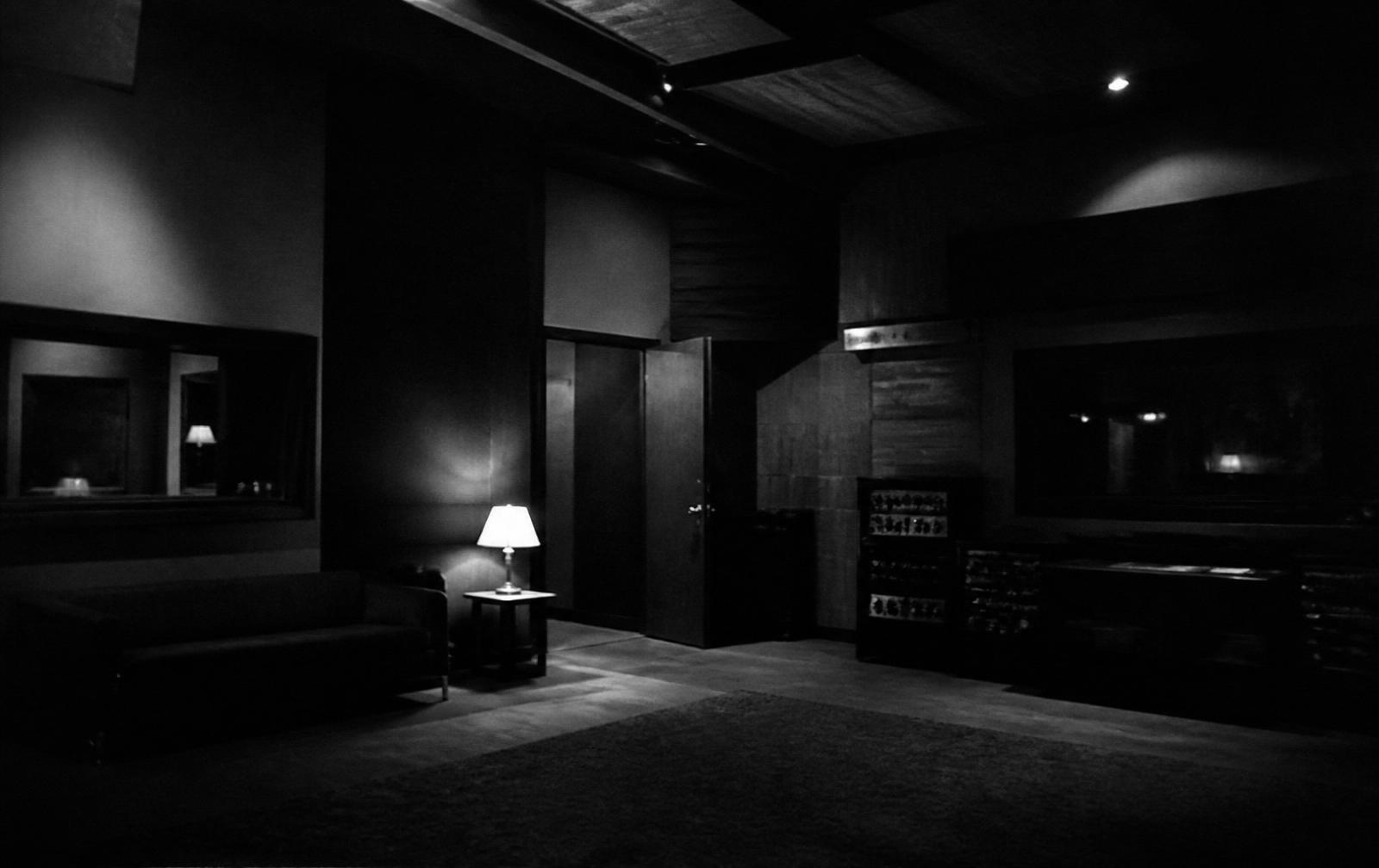 An empty recording studio lit by a single lamp